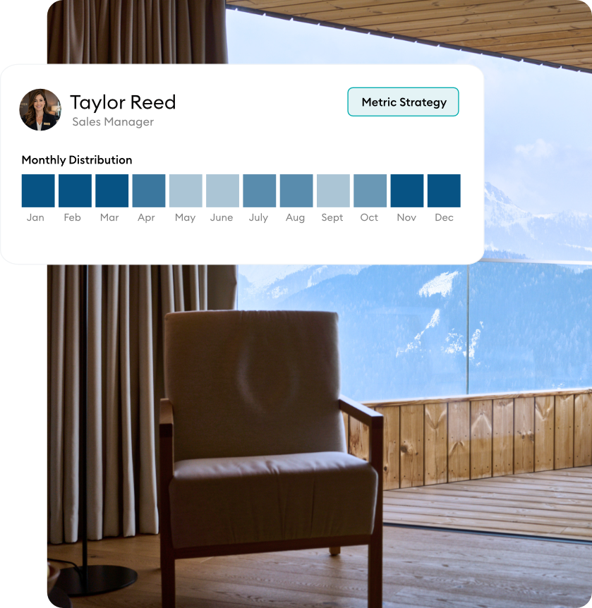 An armchair indoors overlooking a snowy mountain resort landscape.